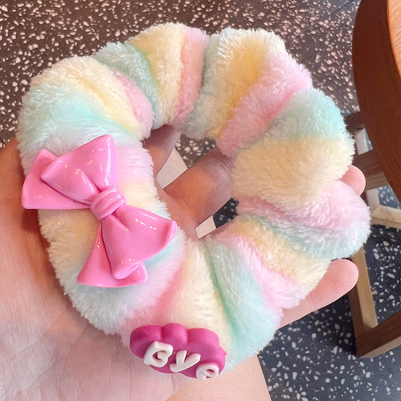 A vibrant set of four plush Barbie hair scrunchies in various playful designs, perfect for adding color to hairstyles.