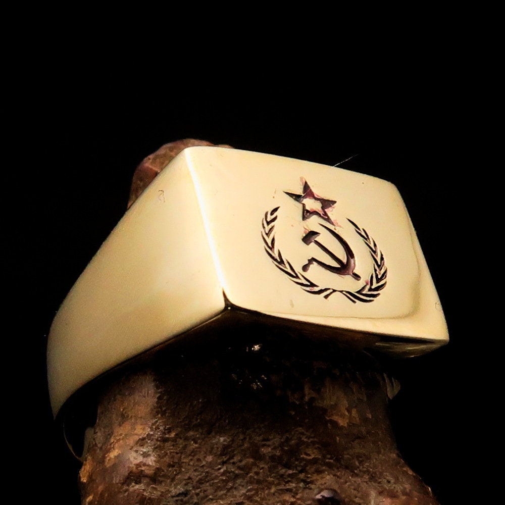 A square-shaped Communist Costume Ring with a red Hammer and Sickle design, crafted from polished brass, ideal for pinky fingers.