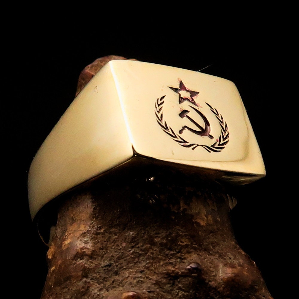 A square-shaped Communist Costume Ring with a red Hammer and Sickle design, crafted from polished brass, ideal for pinky fingers.