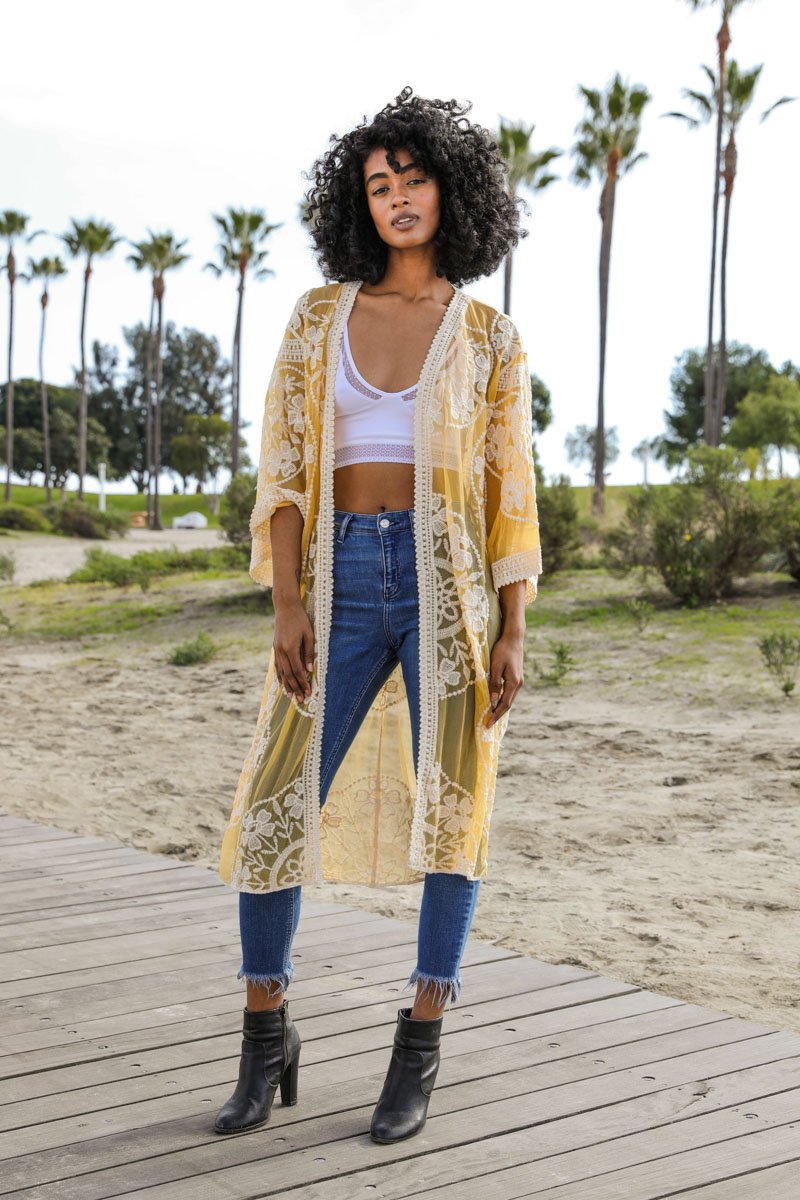 A lightweight embroidered kimono featuring contrast mesh and lace details, perfect for a boho-chic style in spring and summer.