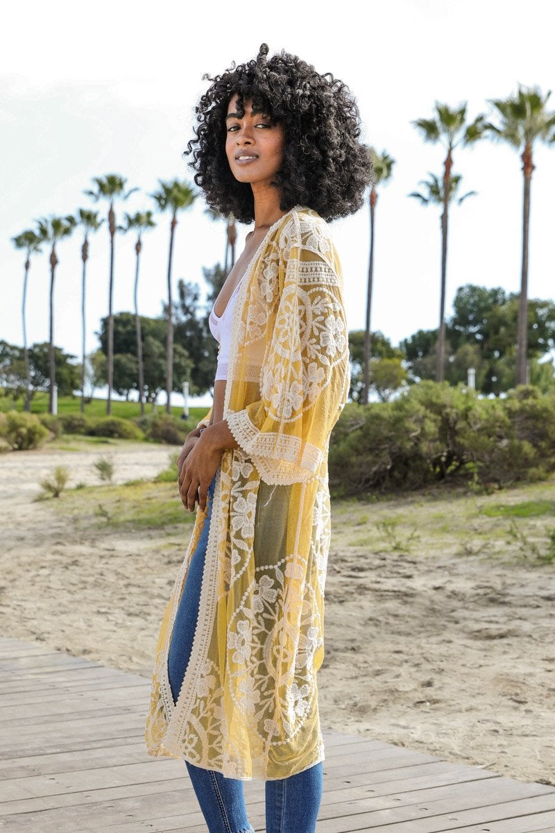 A lightweight embroidered kimono featuring contrast mesh and lace details, perfect for a boho-chic style in spring and summer.