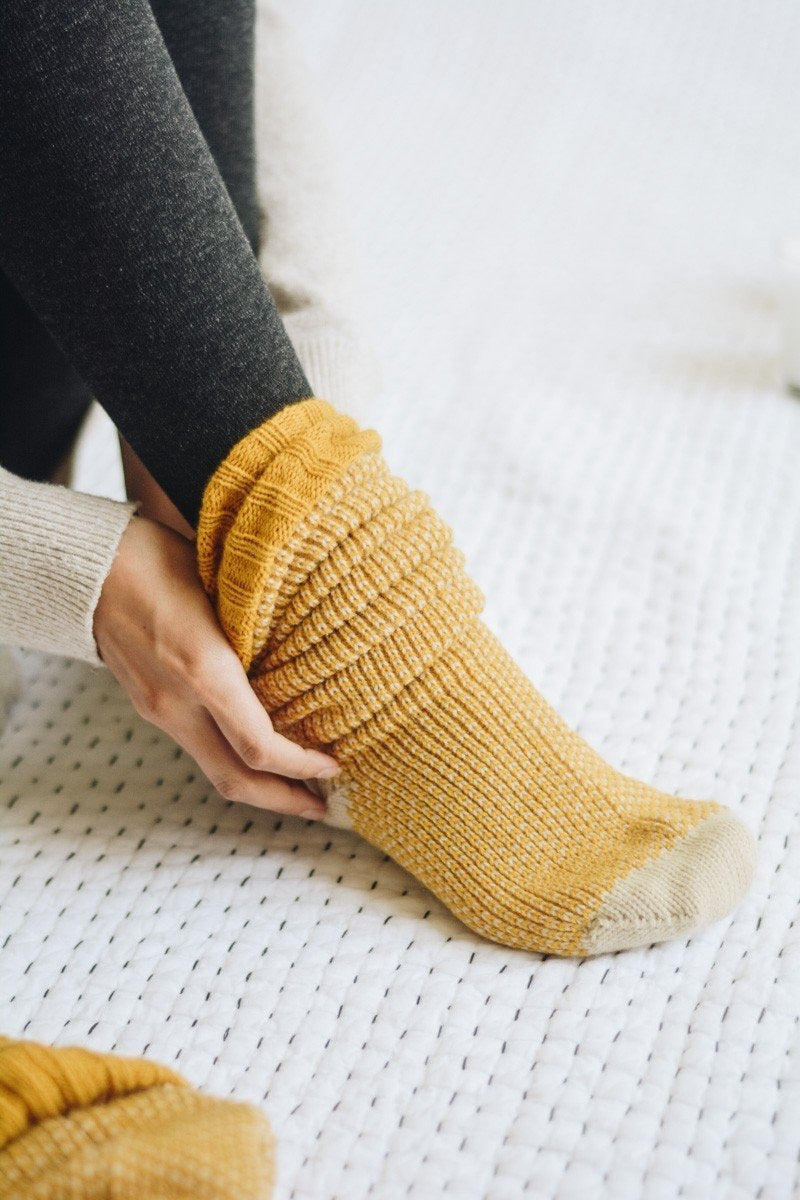 A pair of Cozy Ribbed Knit Lounge Socks in a soft acrylic material, featuring a stylish ribbed design, perfect for chilly days.