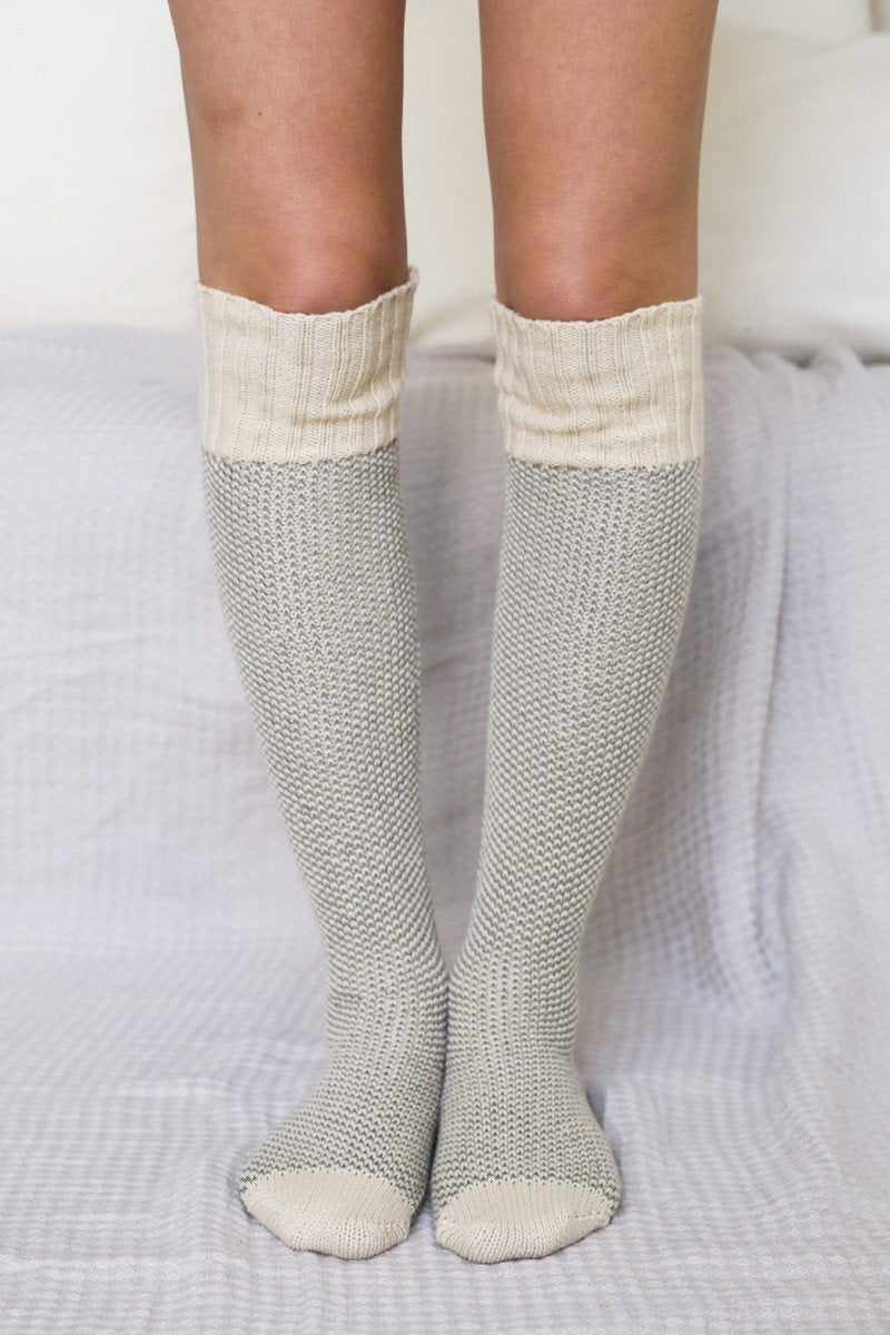 A pair of Cozy Ribbed Knit Lounge Socks in a soft acrylic material, featuring a stylish ribbed design, perfect for chilly days.