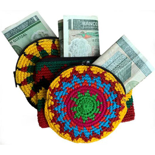 A colorful crocheted coin purse filled with Guatemalan money, showcasing intricate handmade craftsmanship.