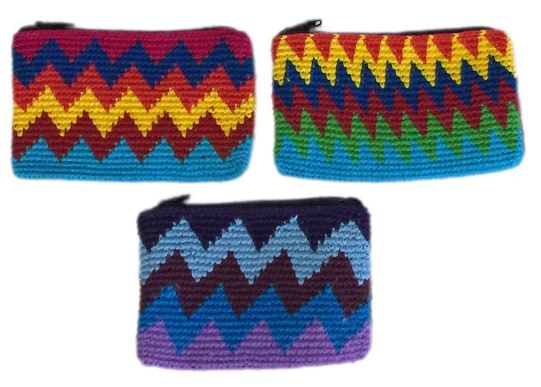 A colorful crocheted coin purse filled with Guatemalan money, showcasing intricate handmade craftsmanship.