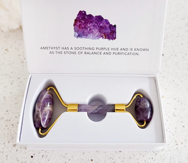 A beautiful Crystal Facial Roller made of Amethyst and Rose Quartz, designed for skincare and relaxation.