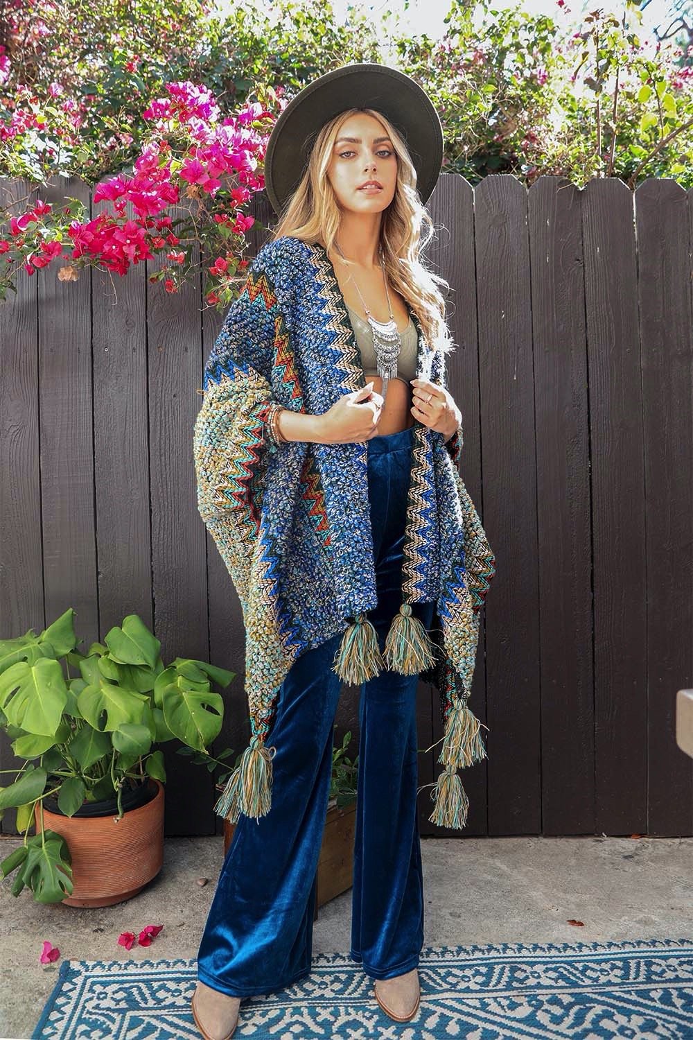 A cozy crochet patterned ruana with tassels, showcasing a boho-chic style, perfect for chilly weather.