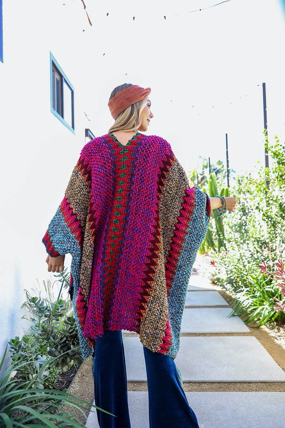 A cozy crochet patterned ruana with tassels, showcasing a boho-chic style, perfect for chilly weather.