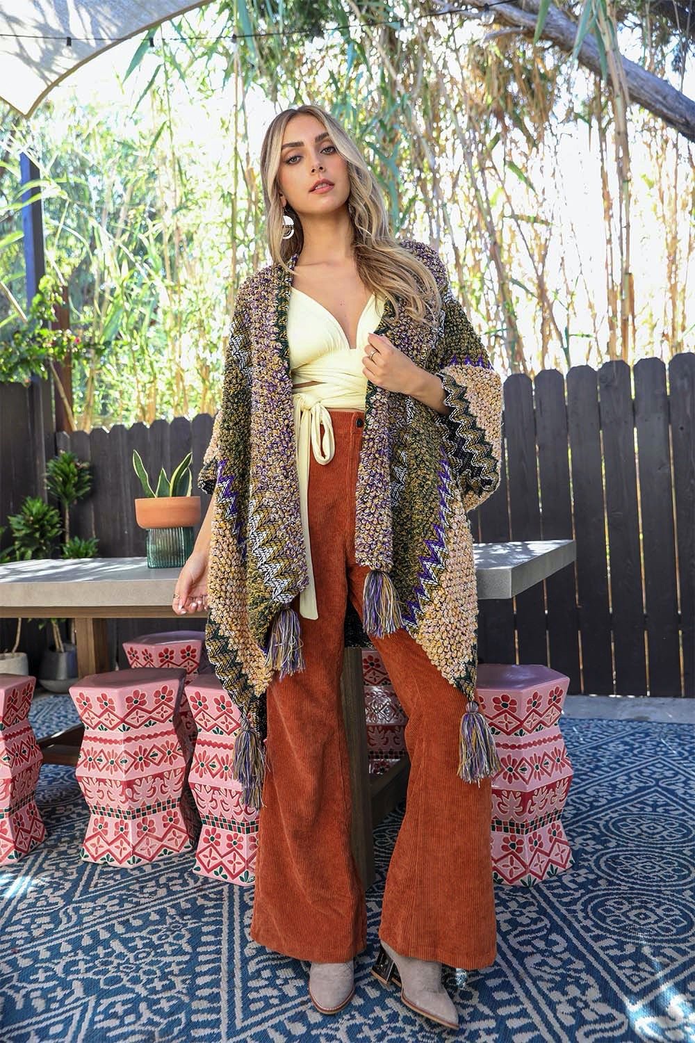 A cozy crochet patterned ruana with tassels, showcasing a boho-chic style, perfect for chilly weather.