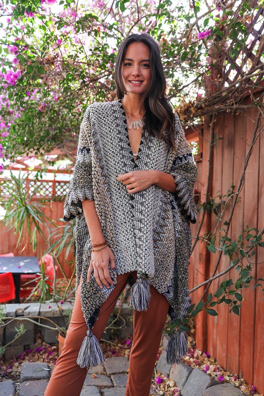 A cozy crochet patterned ruana with tassels, showcasing a boho-chic style, perfect for chilly weather.