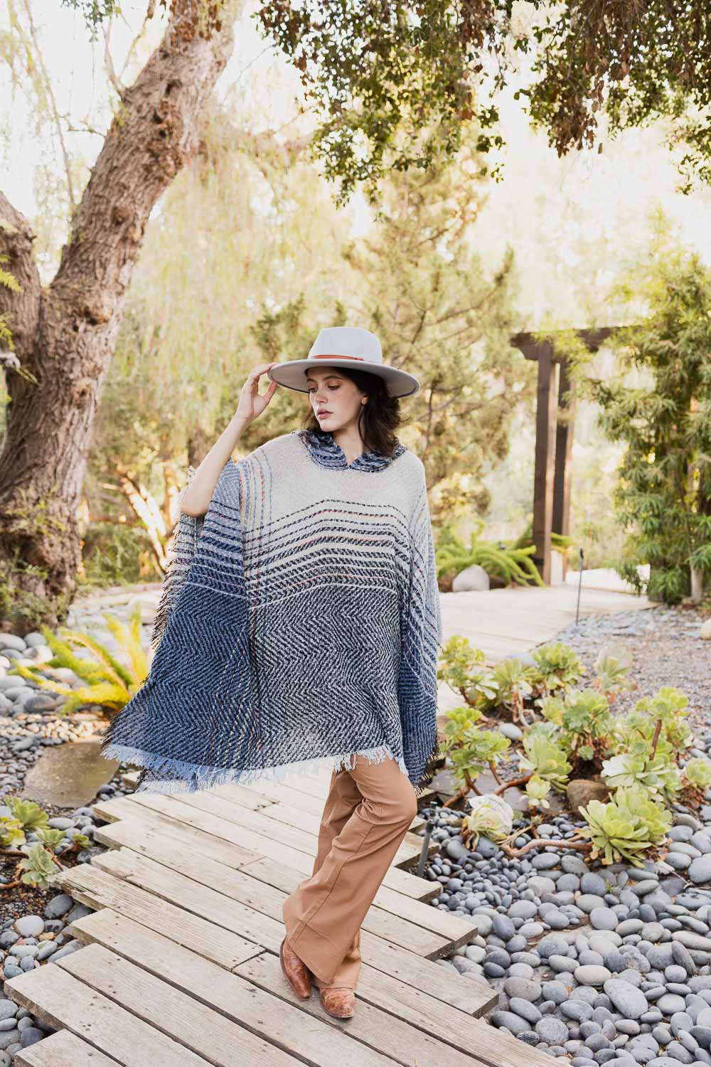 A cozy Cuddly Herringbone Hooded Poncho featuring a stylish herringbone pattern and a cute hood, perfect for chilly weather.