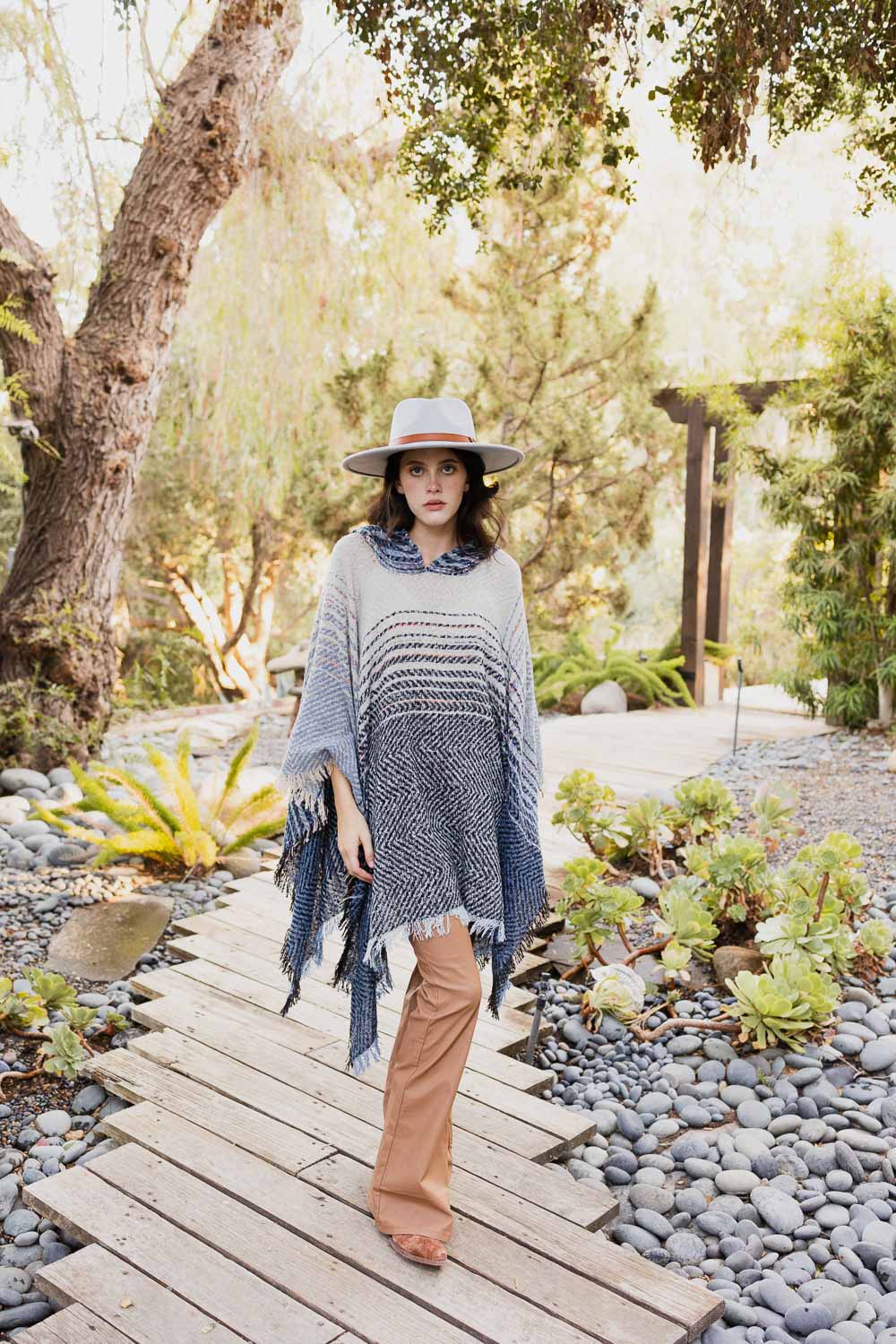 A cozy Cuddly Herringbone Hooded Poncho featuring a stylish herringbone pattern and a cute hood, perfect for chilly weather.