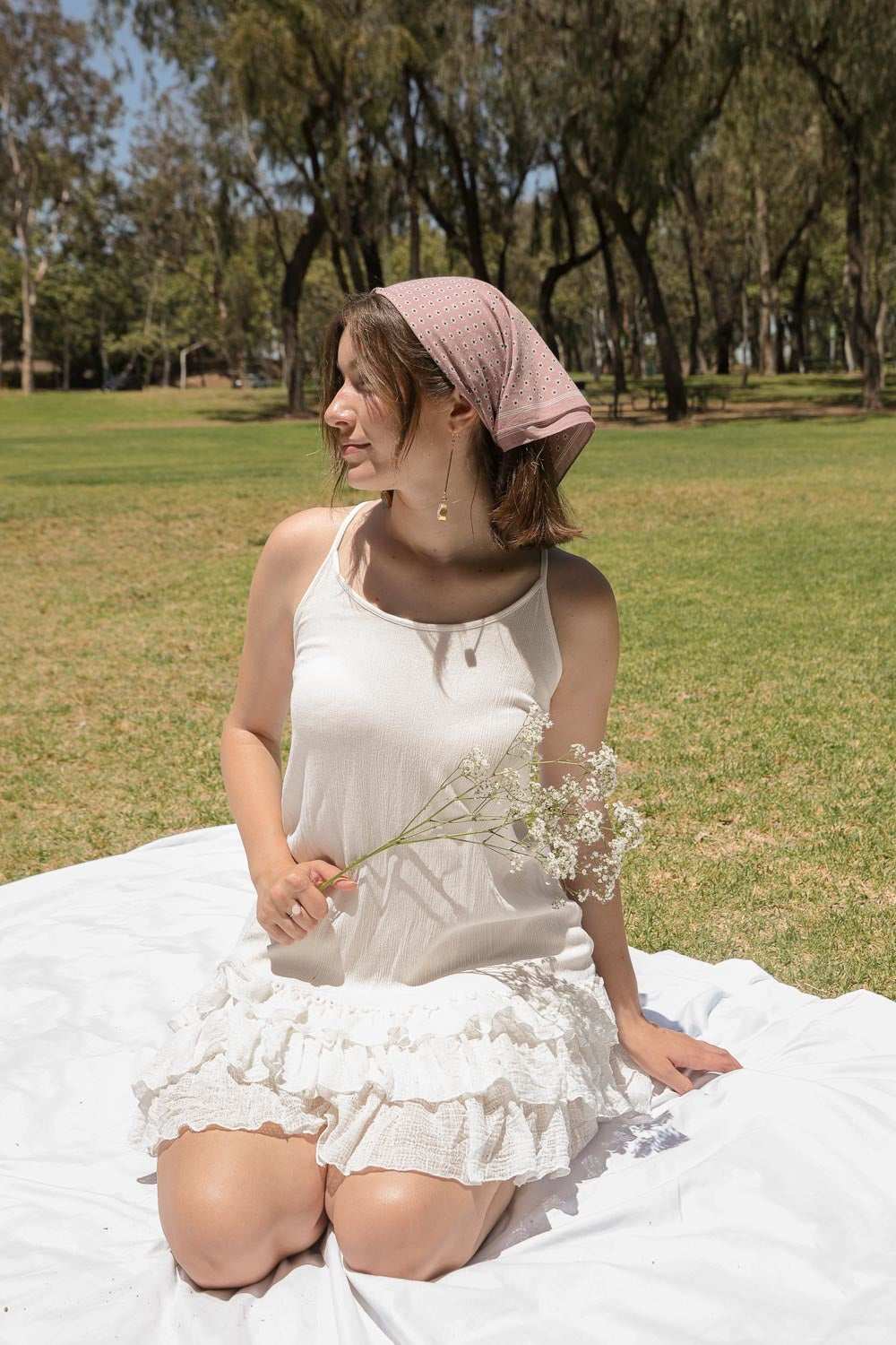 Daisy Flower Field Bandana featuring a vibrant floral print, styled as a hair wrap and neck scarf.