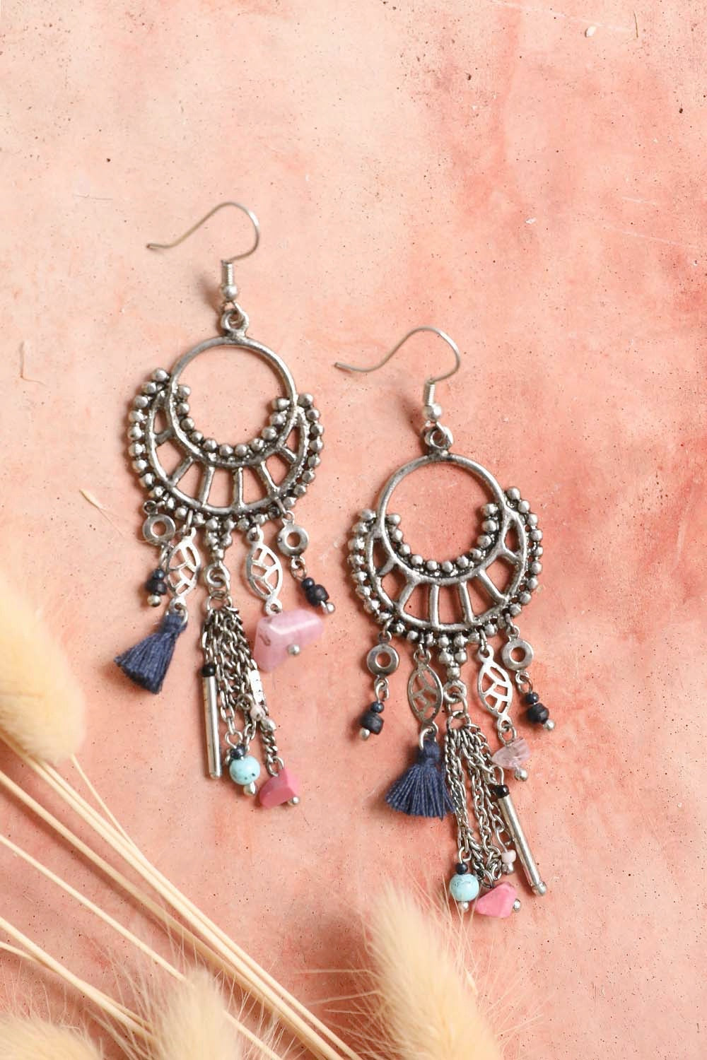 Dangling earrings featuring rose quartz beads and delicate fringe, showcasing elegance and style.