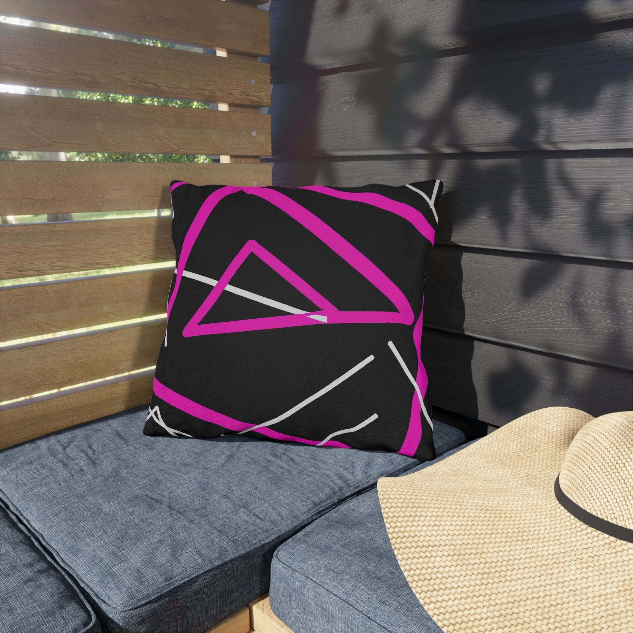 Decorative indoor/outdoor pillow featuring a black and pink geometric pattern, showcasing vibrant colors and unique design.