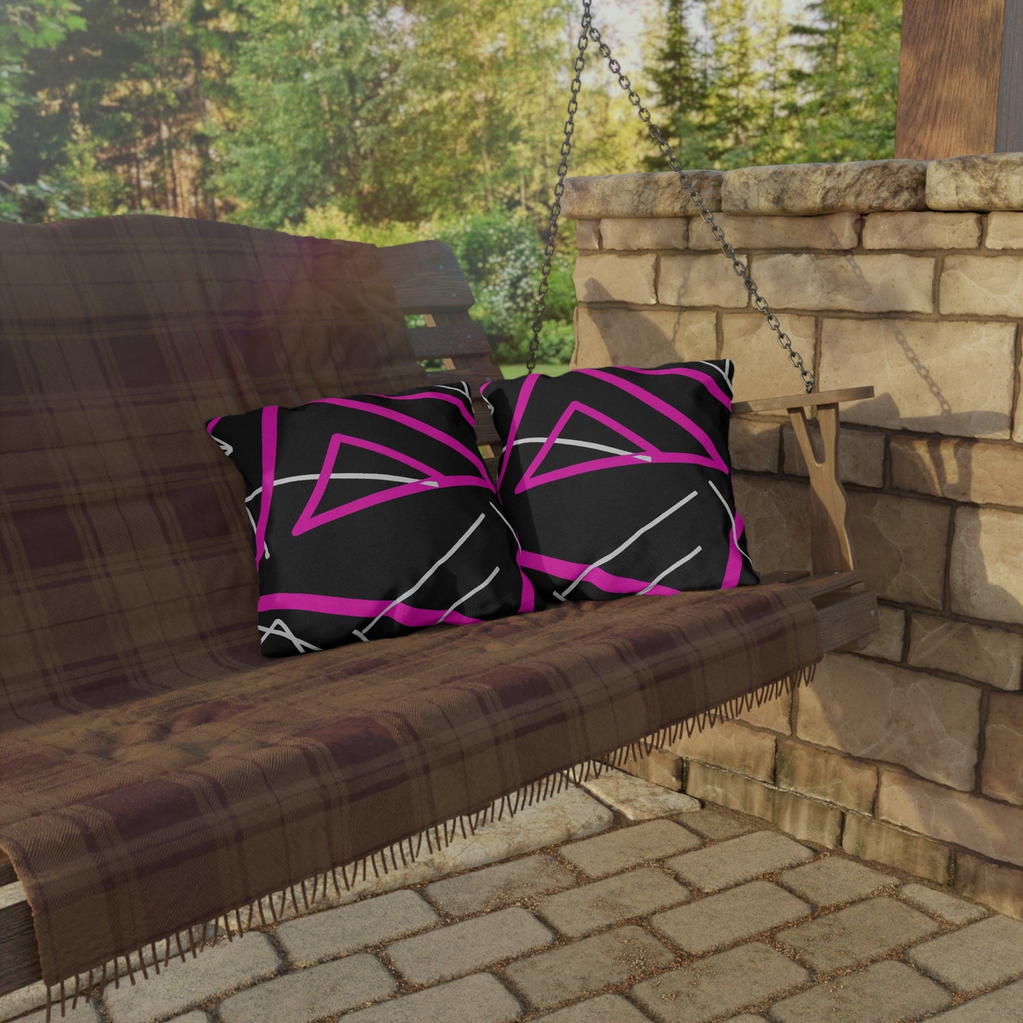 Decorative indoor/outdoor pillow featuring a black and pink geometric pattern, showcasing vibrant colors and unique design.