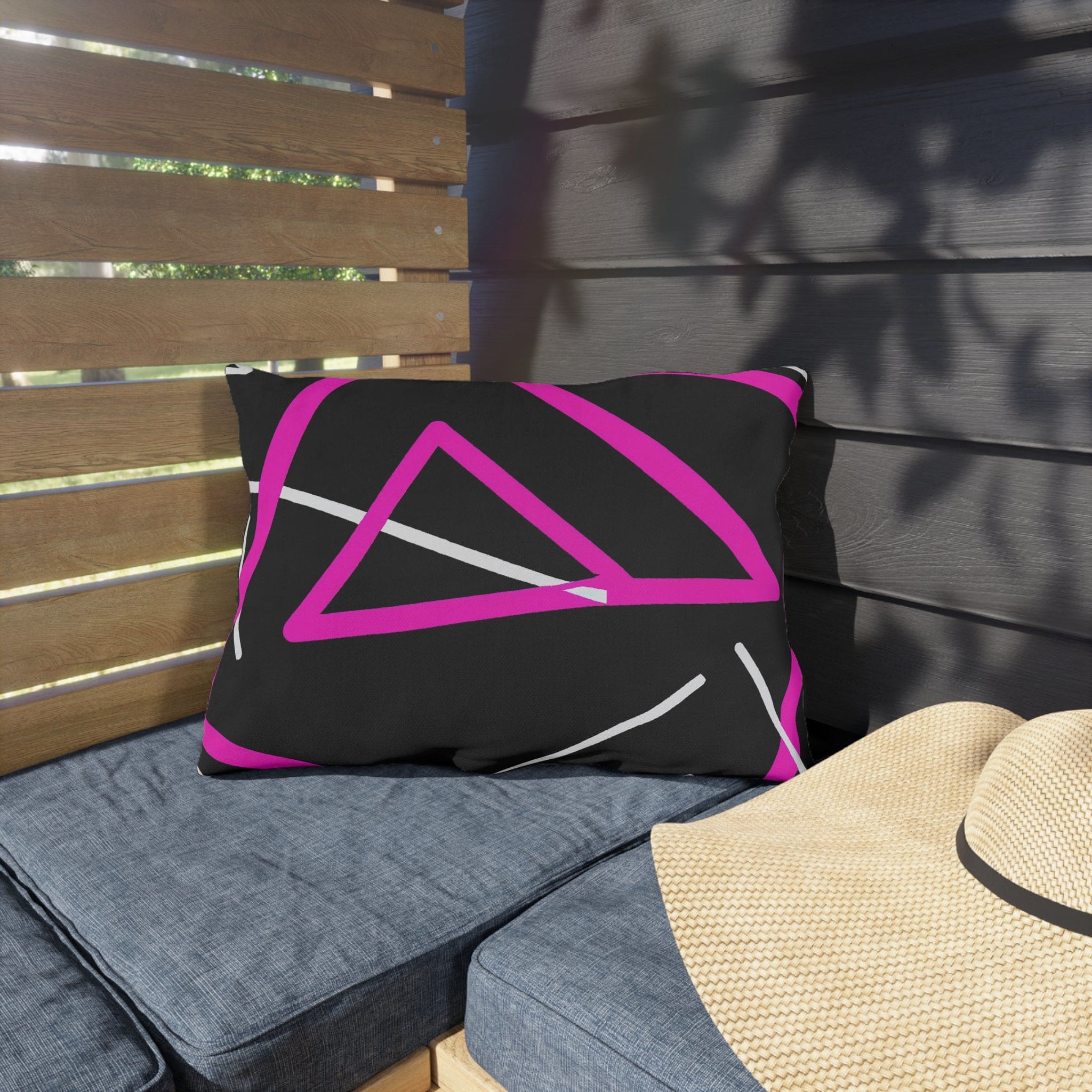 Decorative indoor/outdoor pillow featuring a black and pink geometric pattern, showcasing vibrant colors and unique design.