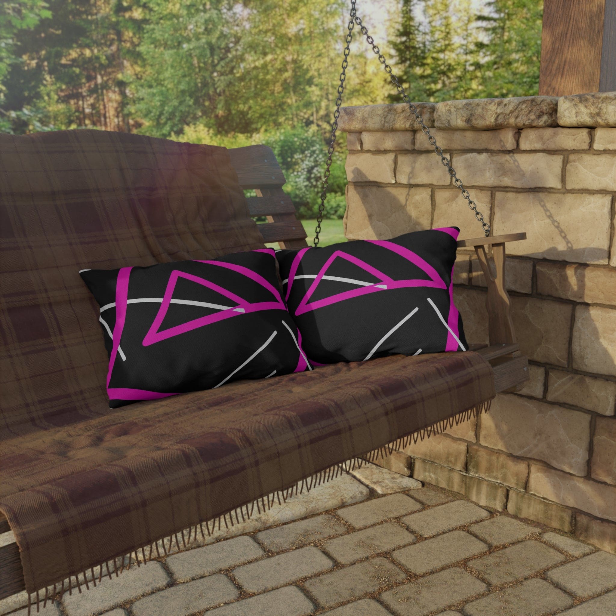 Decorative indoor/outdoor pillow featuring a black and pink geometric pattern, showcasing vibrant colors and unique design.