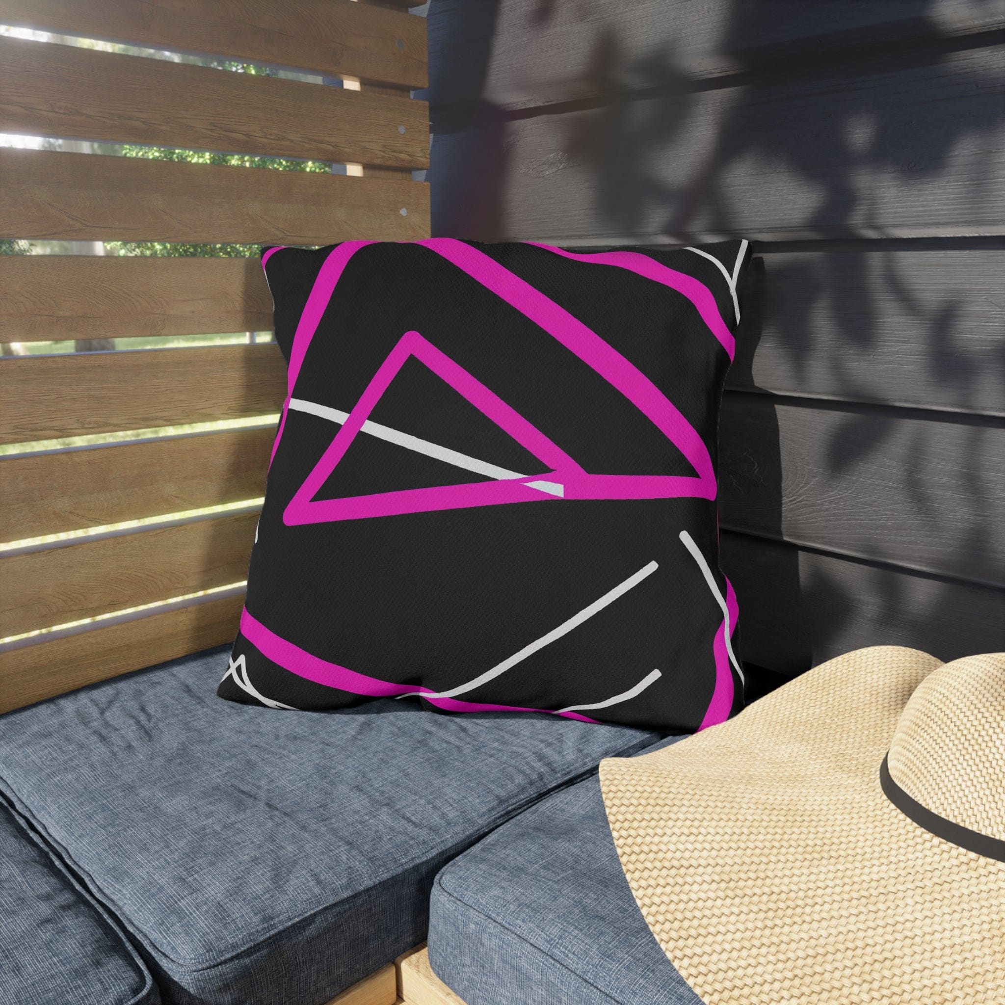 Decorative indoor/outdoor pillow featuring a black and pink geometric pattern, showcasing vibrant colors and unique design.