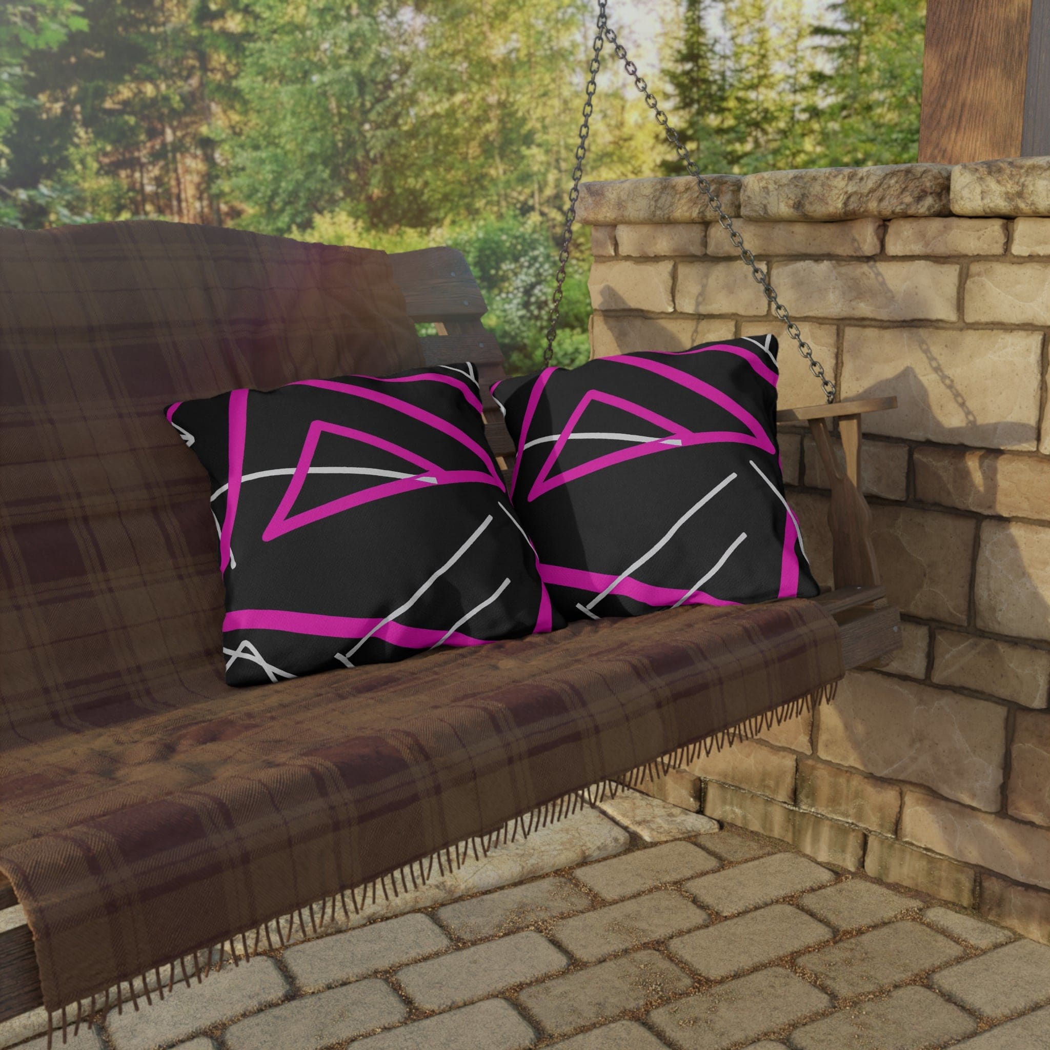 Decorative indoor/outdoor pillow featuring a black and pink geometric pattern, showcasing vibrant colors and unique design.