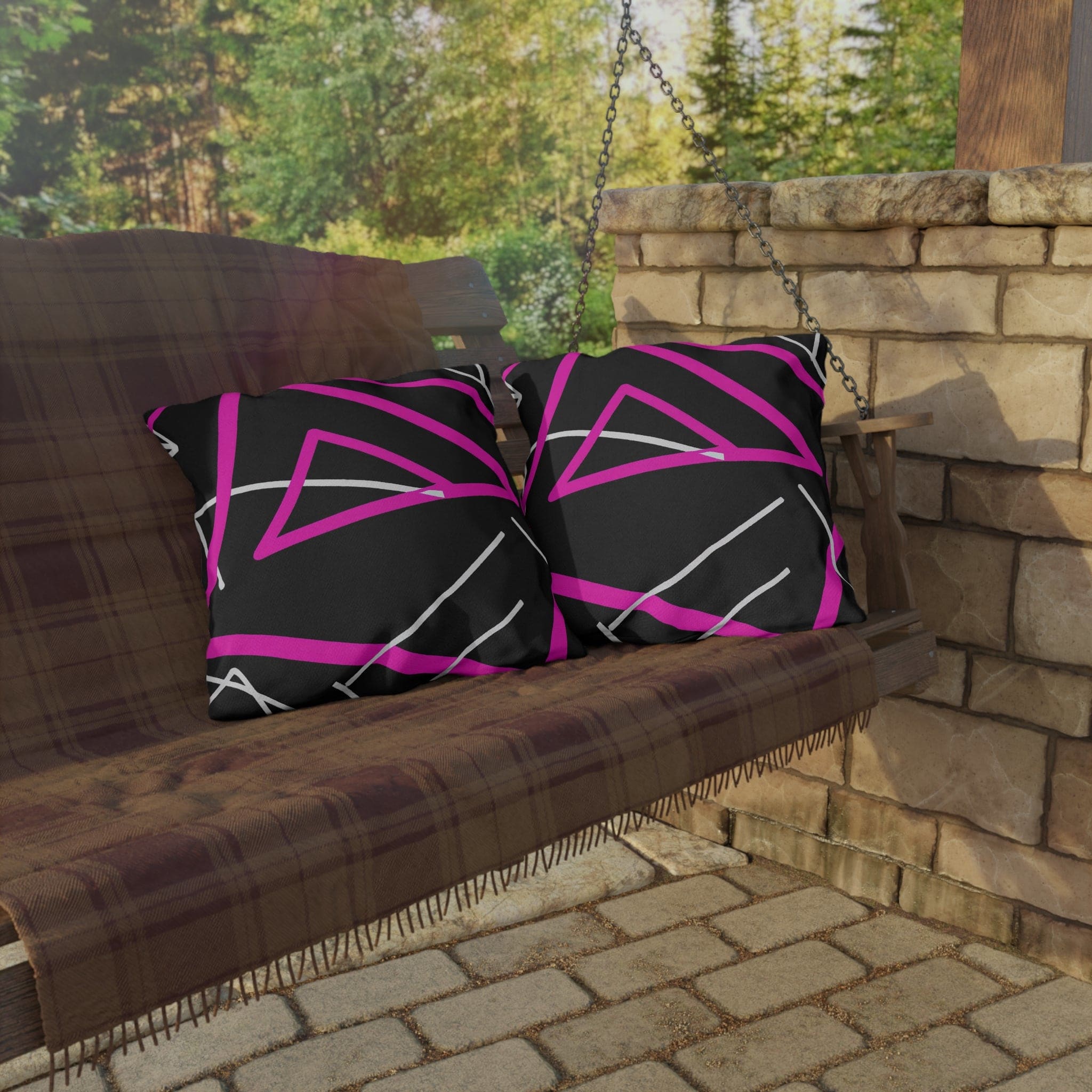 Decorative indoor/outdoor pillow featuring a black and pink geometric pattern, showcasing vibrant colors and unique design.