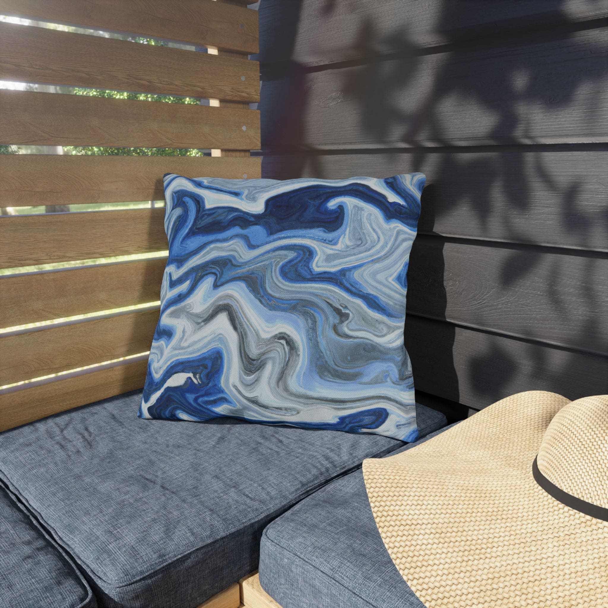 Decorative indoor/outdoor pillow featuring a blue, white, and grey marble pattern, ideal for enhancing outdoor decor.