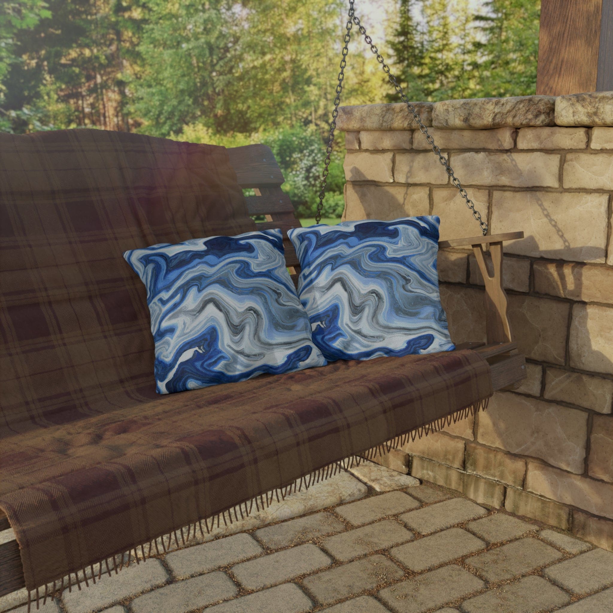 Decorative indoor/outdoor pillow featuring a blue, white, and grey marble pattern, ideal for enhancing outdoor decor.