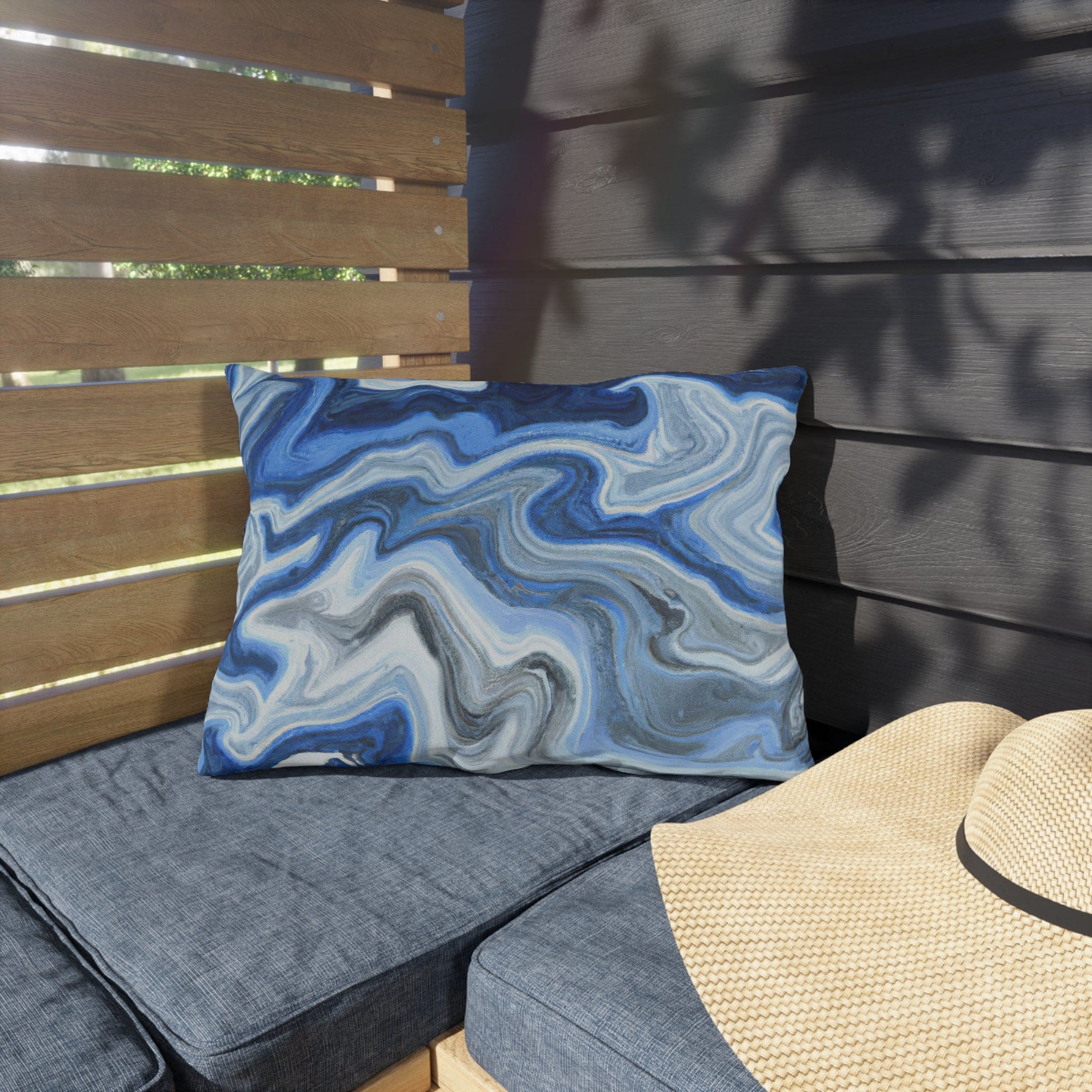 Decorative indoor/outdoor pillow featuring a blue, white, and grey marble pattern, ideal for enhancing outdoor decor.