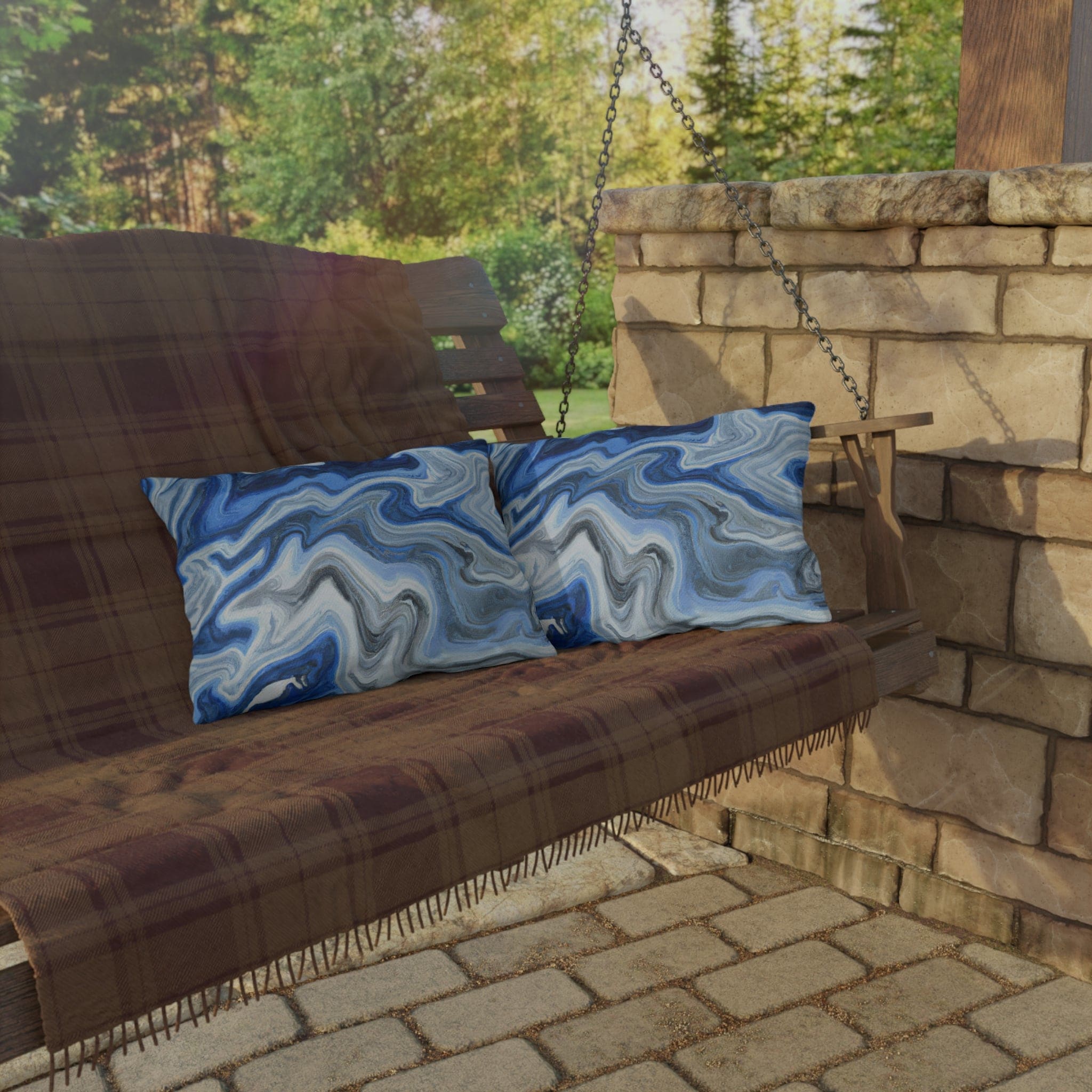 Decorative indoor/outdoor pillow featuring a blue, white, and grey marble pattern, ideal for enhancing outdoor decor.