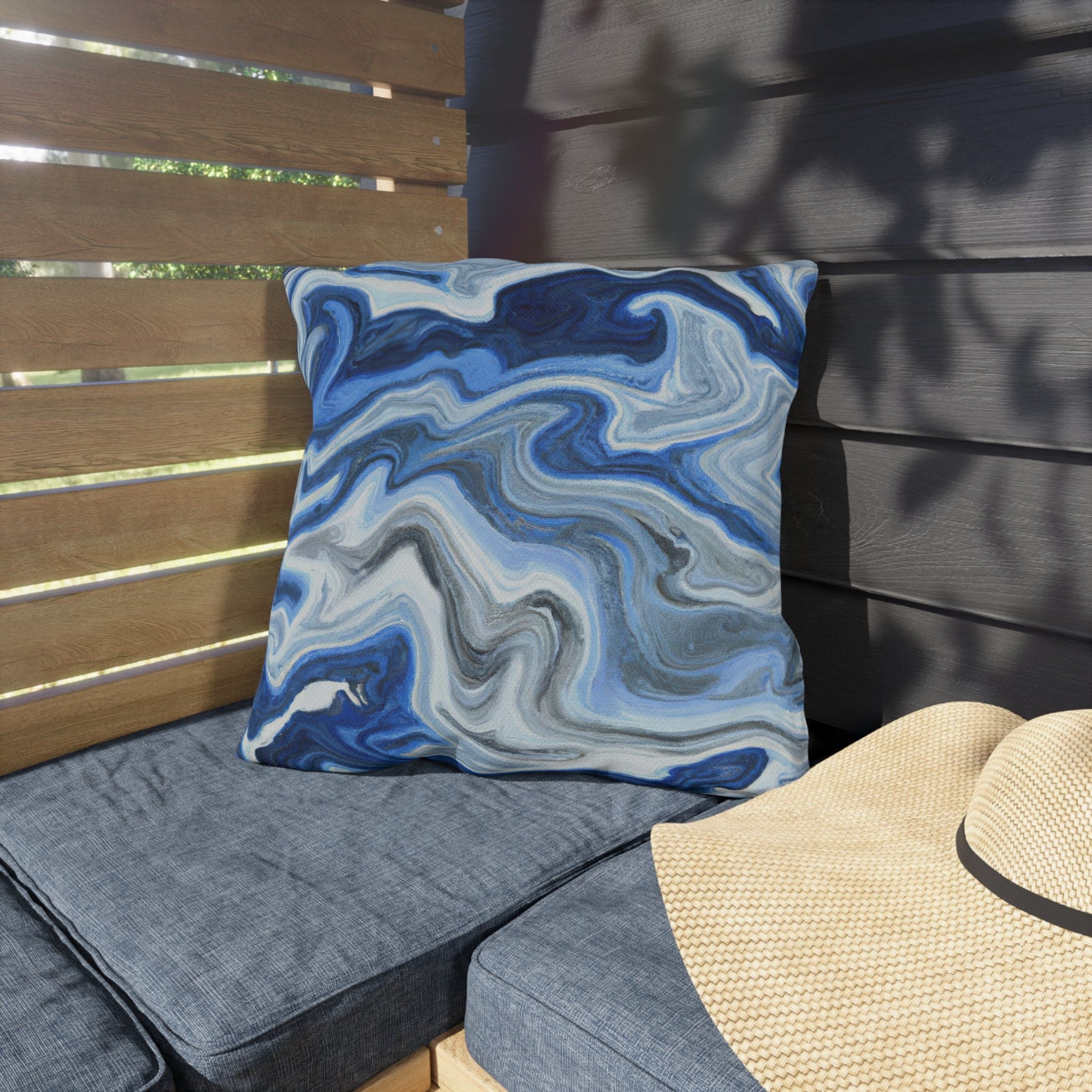 Decorative indoor/outdoor pillow featuring a blue, white, and grey marble pattern, ideal for enhancing outdoor decor.