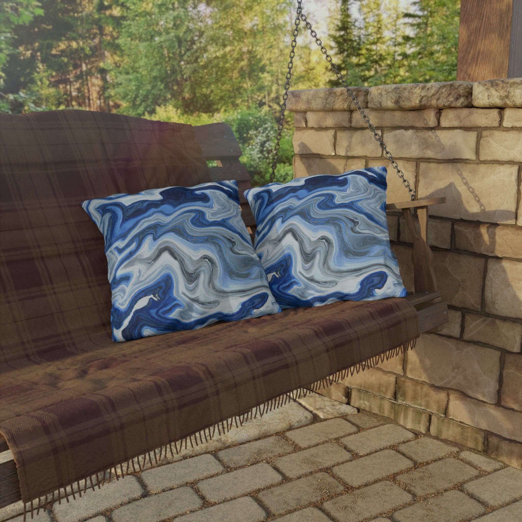 Decorative indoor/outdoor pillow featuring a blue, white, and grey marble pattern, ideal for enhancing outdoor decor.