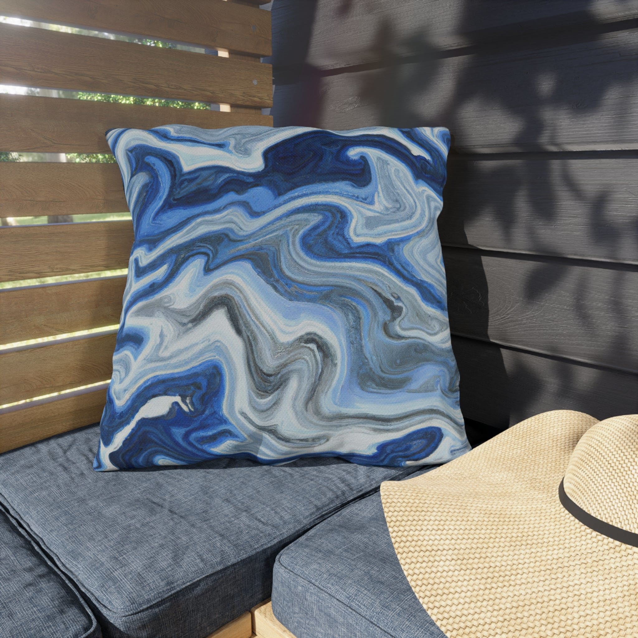 Decorative indoor/outdoor pillow featuring a blue, white, and grey marble pattern, ideal for enhancing outdoor decor.