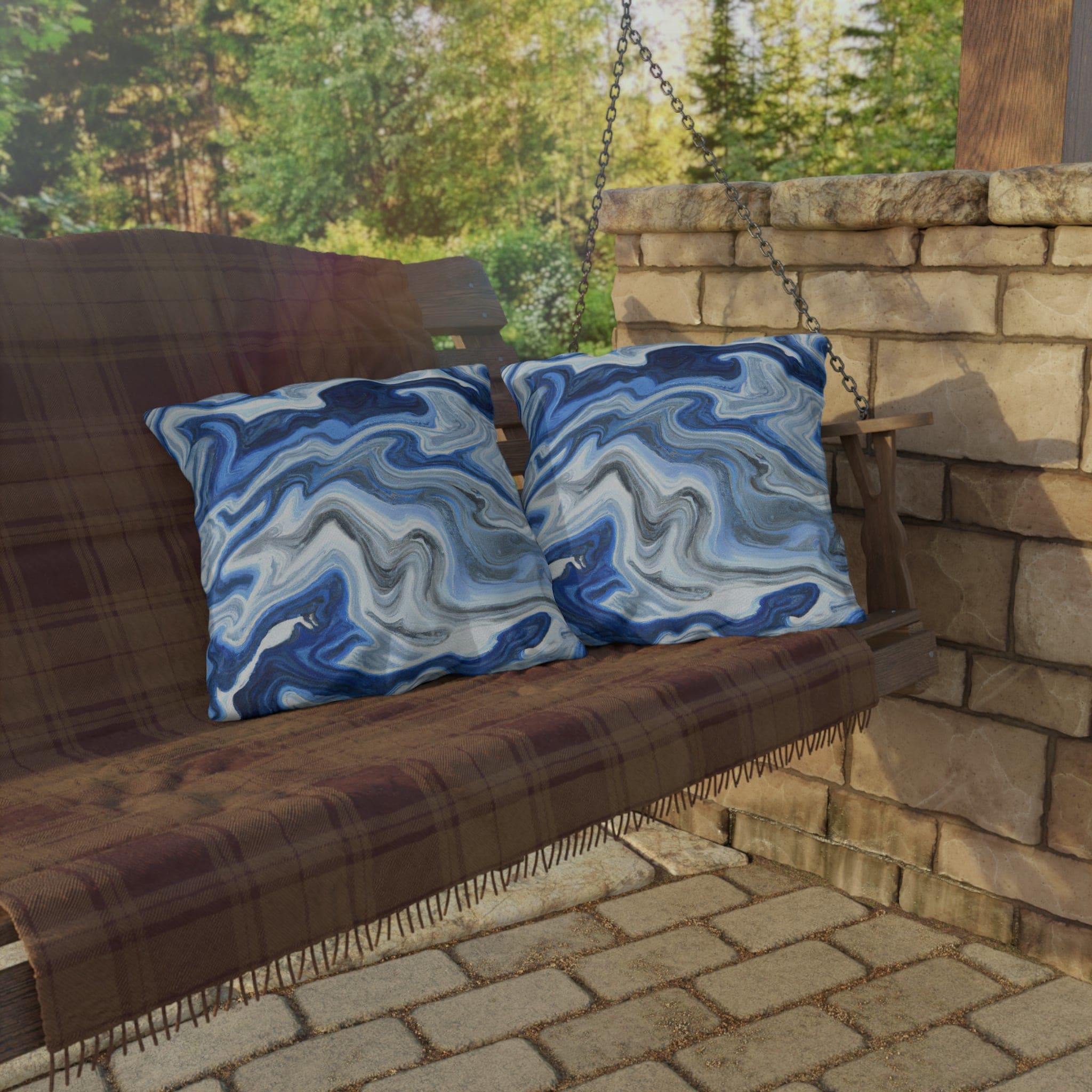 Decorative indoor/outdoor pillow featuring a blue, white, and grey marble pattern, ideal for enhancing outdoor decor.