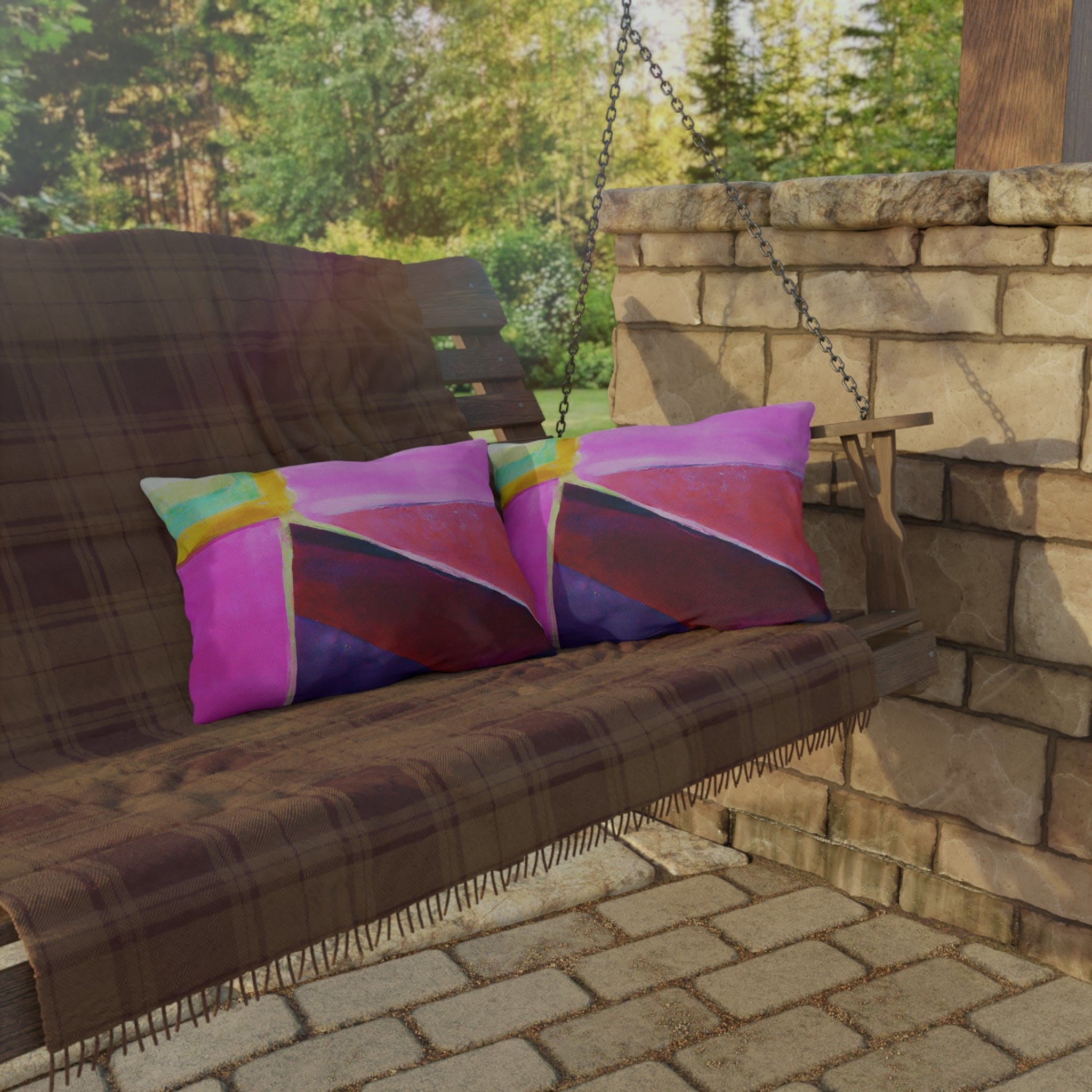 Decorative indoor/outdoor pillow featuring a vibrant pink, purple, and red geometric pattern, ideal for enhancing outdoor decor.