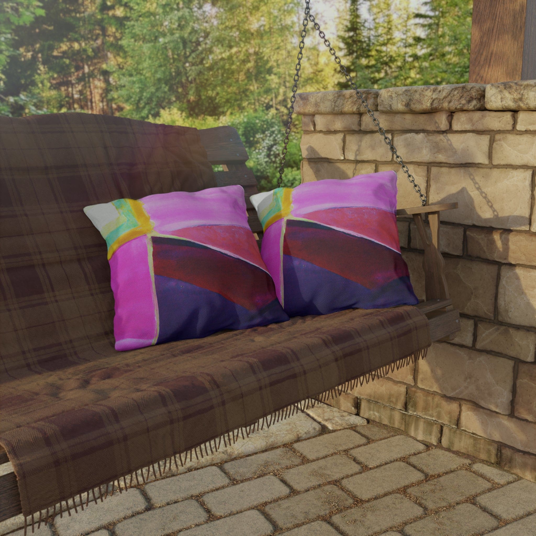 Decorative indoor/outdoor pillow featuring a vibrant pink, purple, and red geometric pattern, ideal for enhancing outdoor decor.