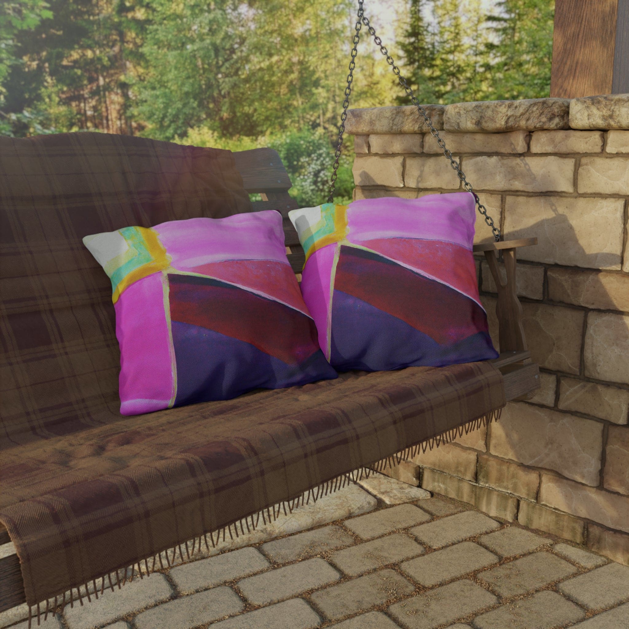 Decorative indoor/outdoor pillow featuring a vibrant pink, purple, and red geometric pattern, ideal for enhancing outdoor decor.