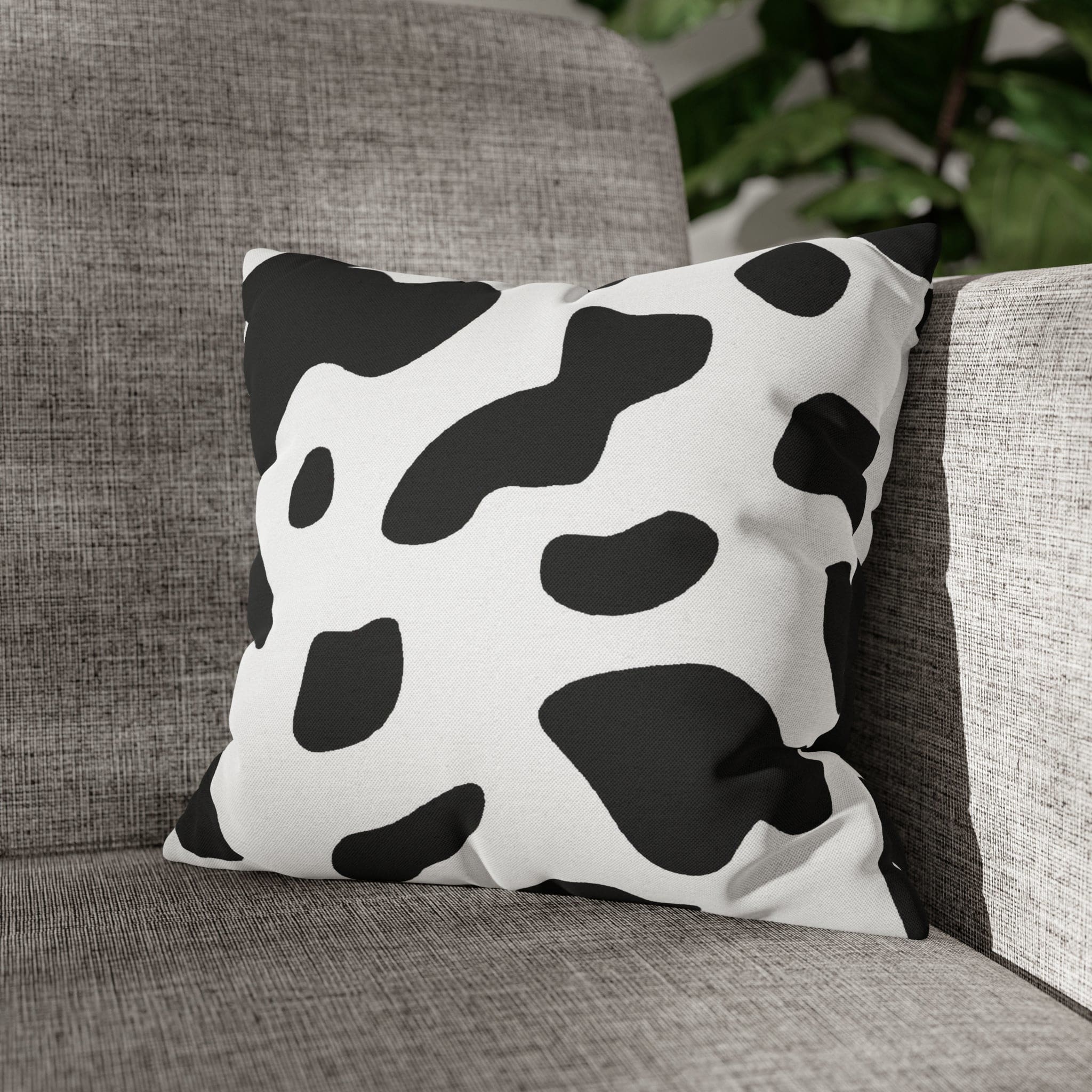 Decorative throw pillow cover featuring a black and white abstract cow print design, showcasing its stylish and modern aesthetic.