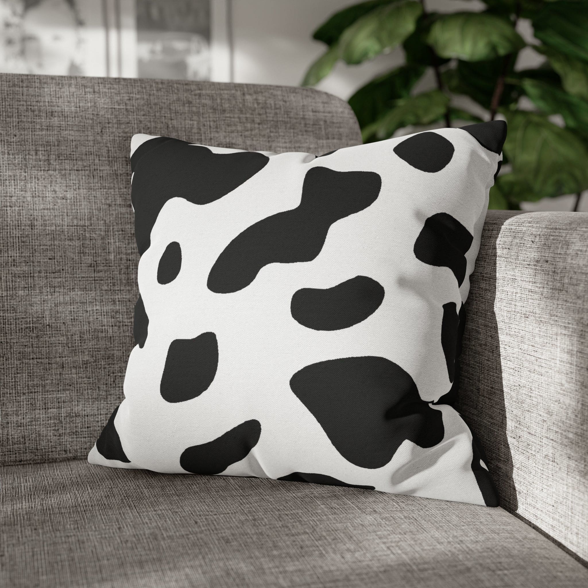 Decorative throw pillow cover featuring a black and white abstract cow print design, showcasing its stylish and modern aesthetic.