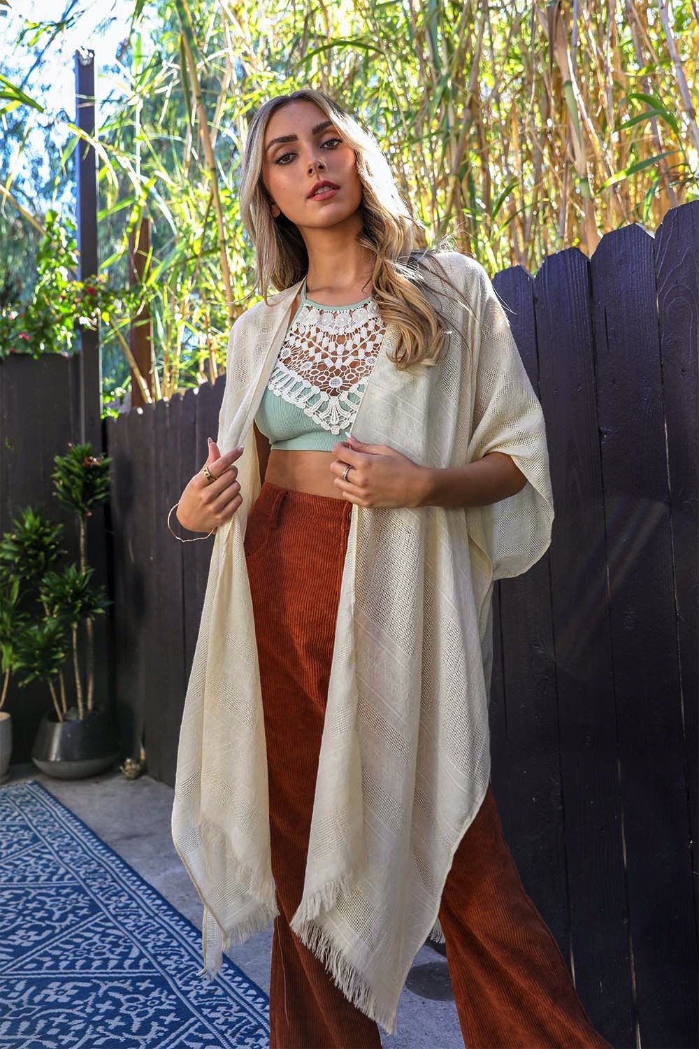 A stylish diamond embroidered kimono featuring frayed edges, perfect for a feminine and trendy look.