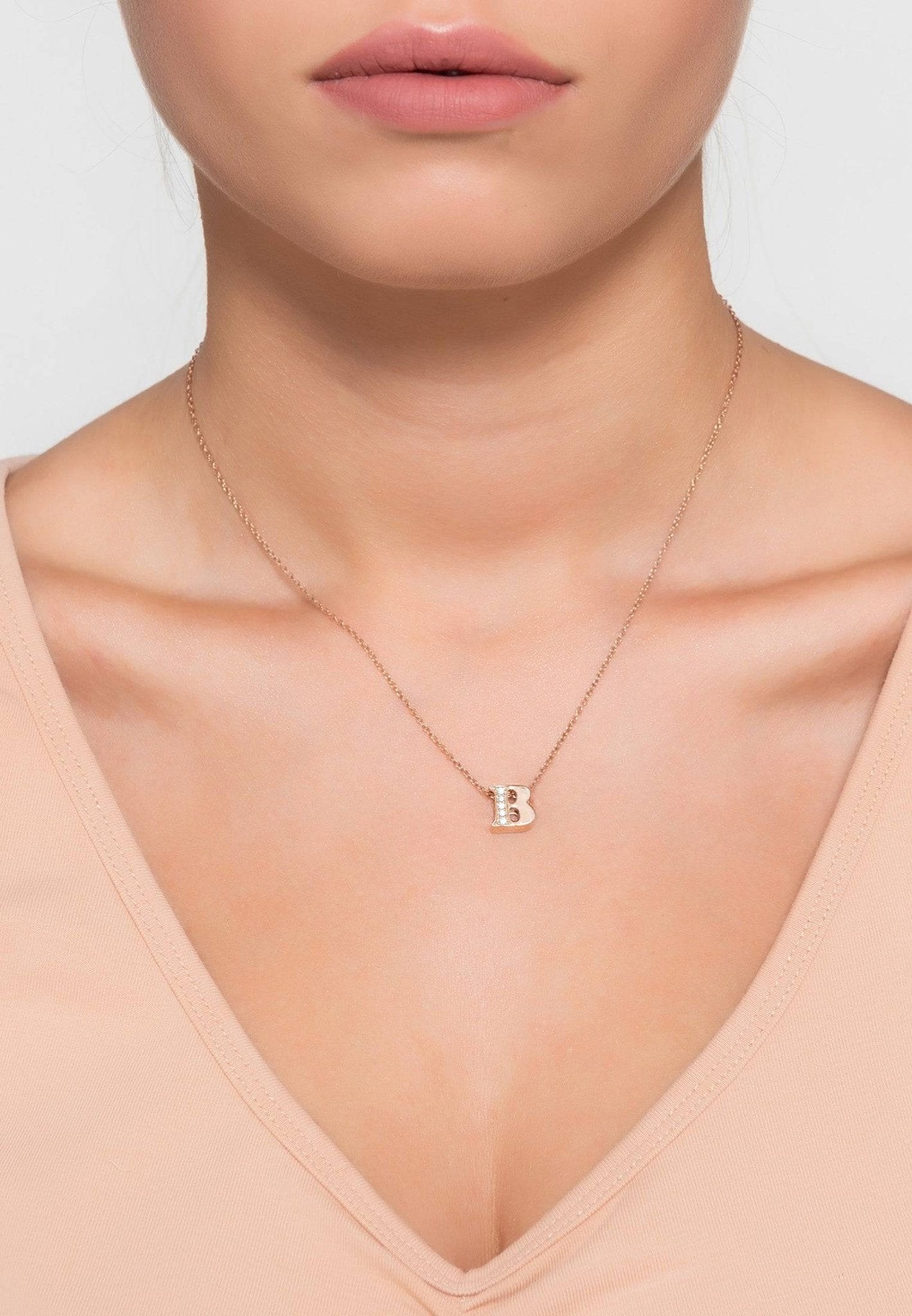 Rose gold initial letter pendant necklace adorned with diamonds, showcasing elegance and personalization.