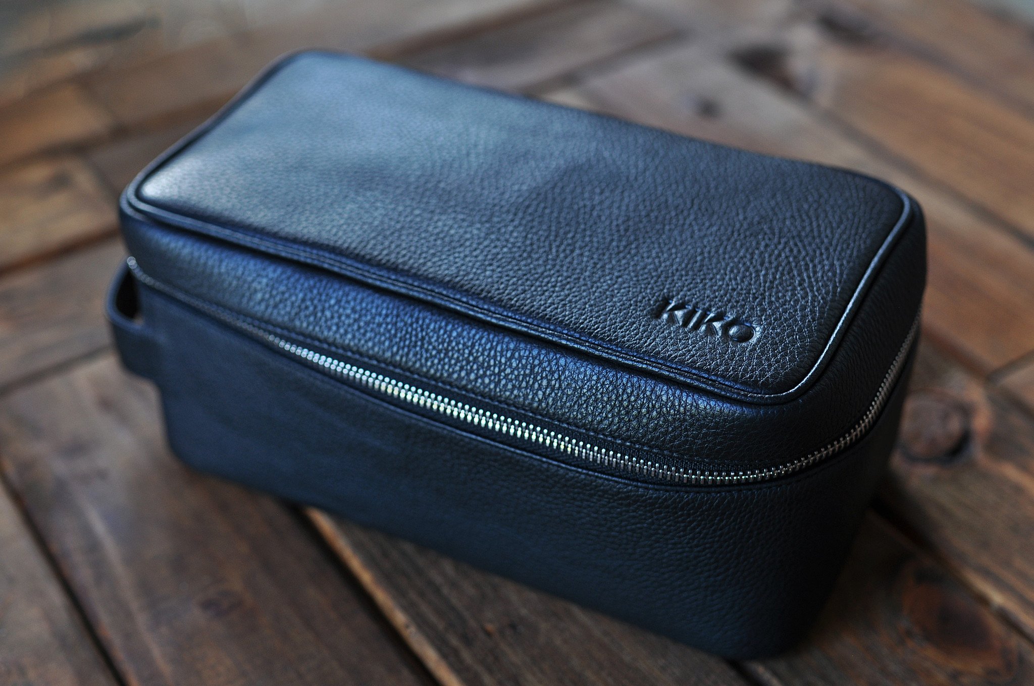 Elegant Dopp Kit made from premium leather with a carrying handle and zipped netted storage area.