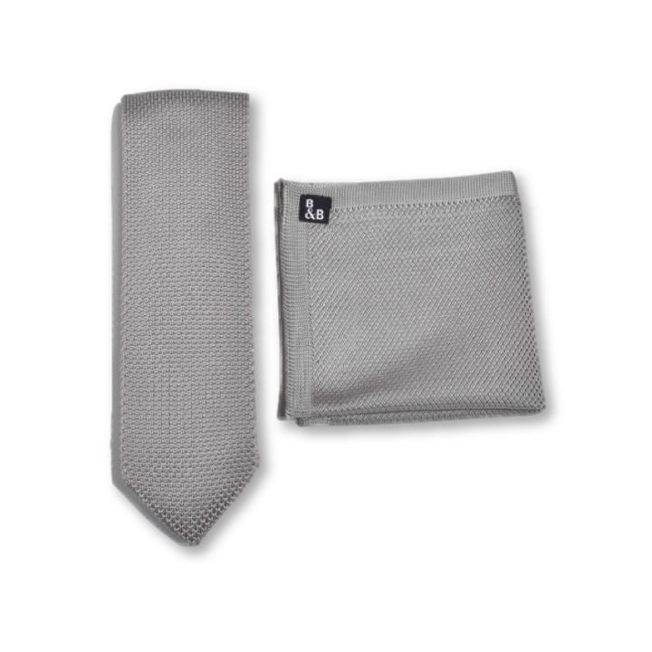 Dove grey knitted tie and pocket square set displayed elegantly, showcasing the textured fabric and pointed tie end.