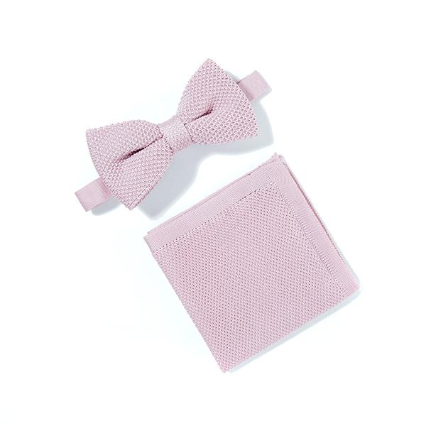 Dusty pink knitted bow tie and matching pocket square set displayed elegantly on a white background.