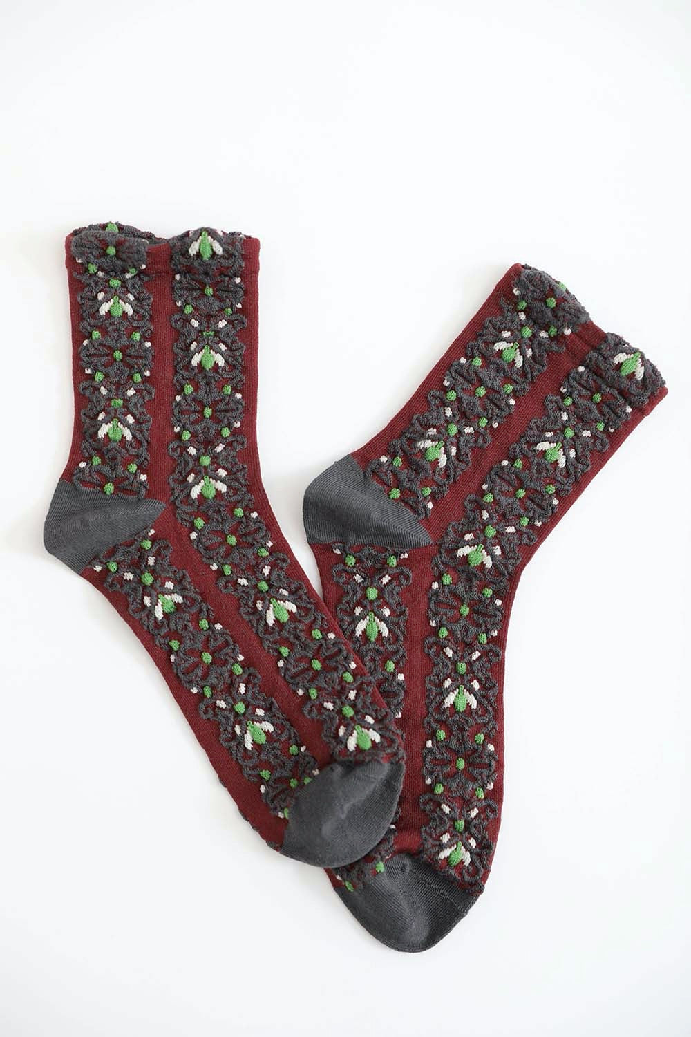 A pair of cozy socks featuring an embroidered flower pattern, showcasing vibrant colors and intricate details.