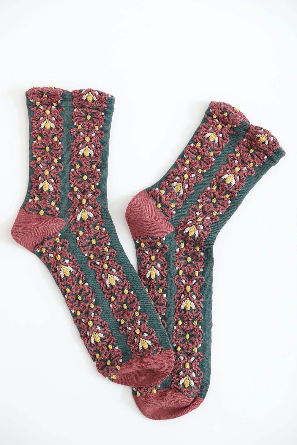 A pair of cozy socks featuring an embroidered flower pattern, showcasing vibrant colors and intricate details.