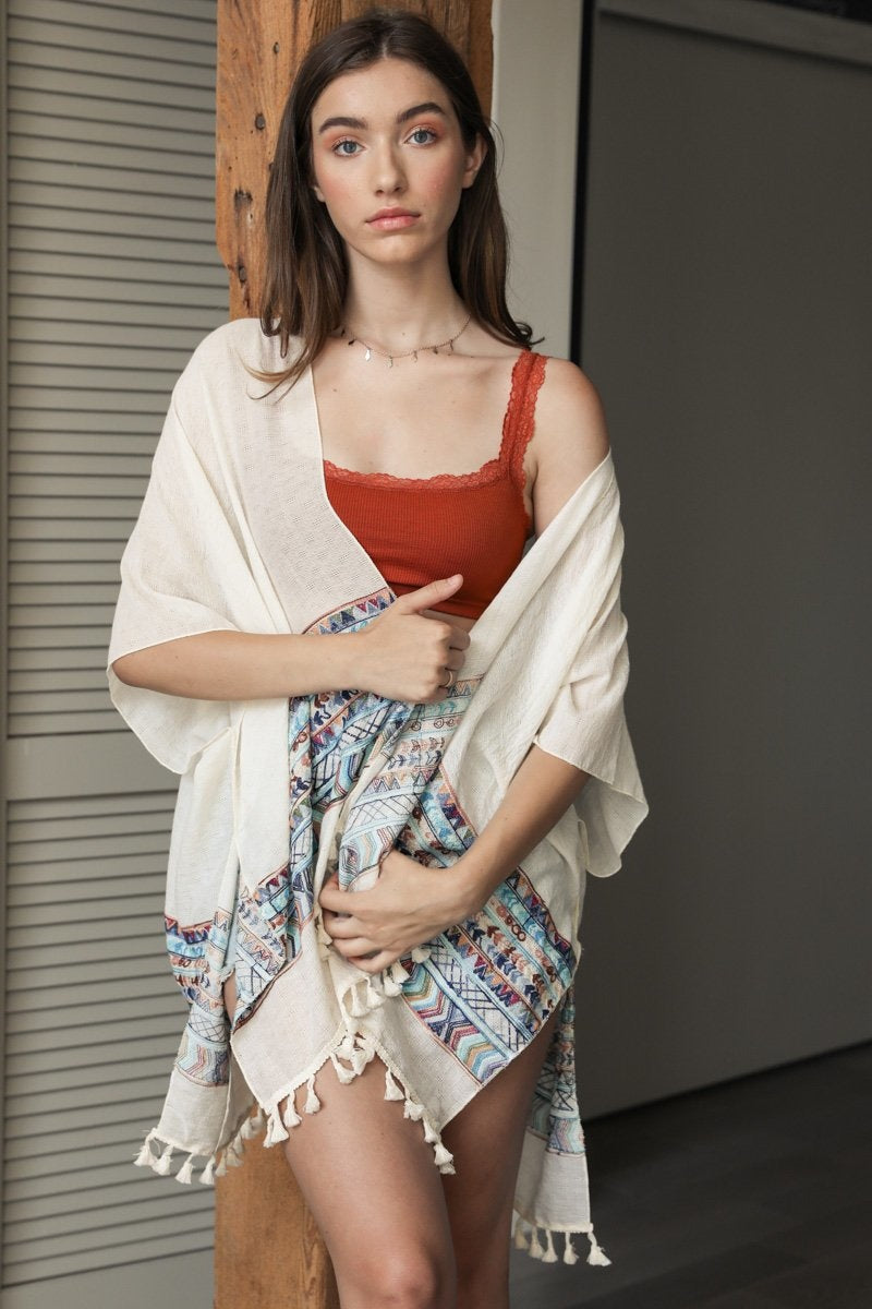 A lightweight linen kimono featuring a vibrant geometric embroidery pattern, perfect for layering or as a swimsuit cover-up.