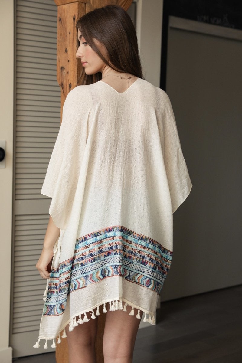 A lightweight linen kimono featuring a vibrant geometric embroidery pattern, perfect for layering or as a swimsuit cover-up.