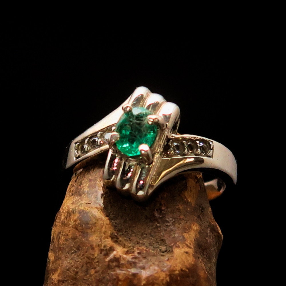 Handmade sterling silver emerald ring featuring an oval cut green emerald and six cubic zirconia stones, hallmarked 925.