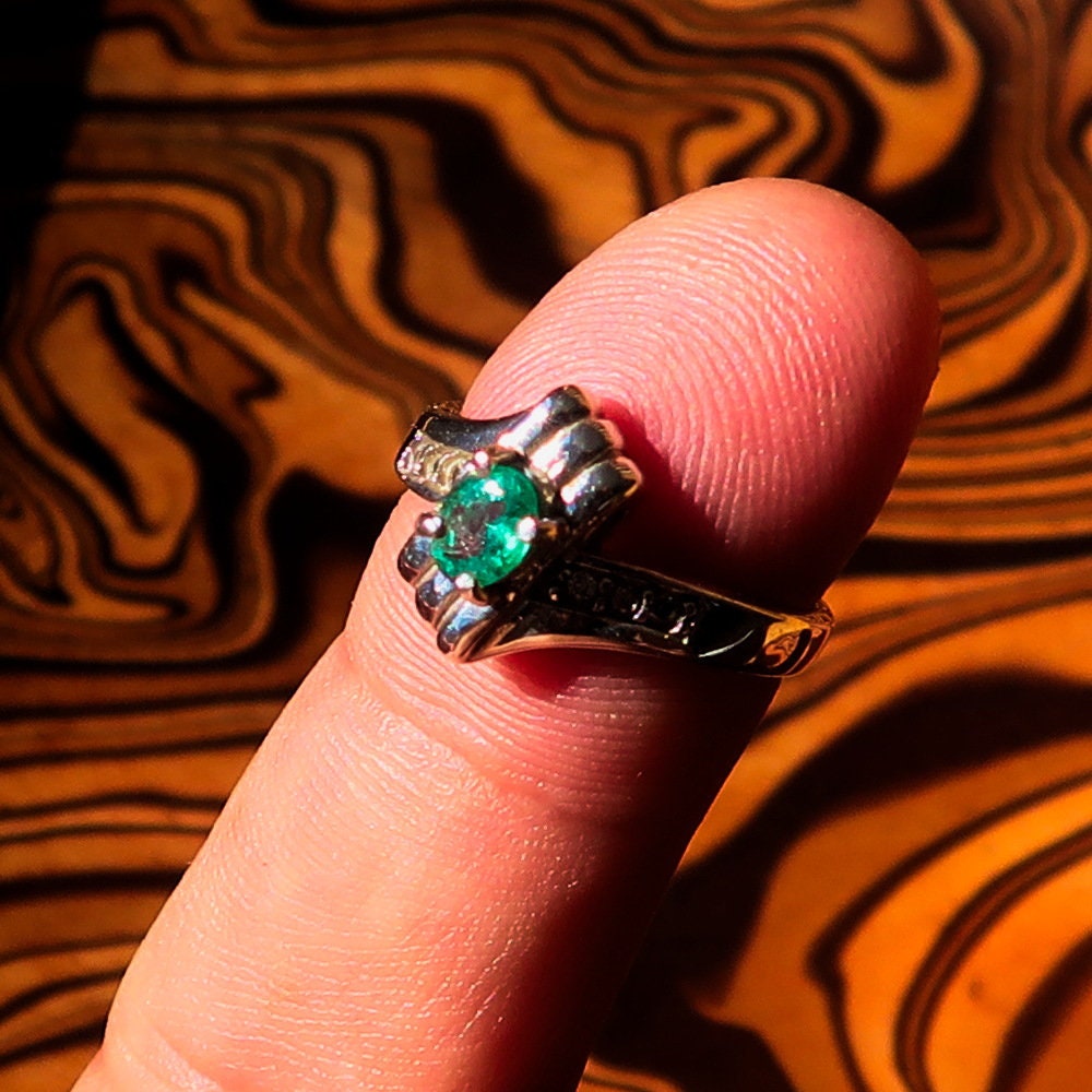 Handmade sterling silver emerald ring featuring an oval cut green emerald and six cubic zirconia stones, hallmarked 925.