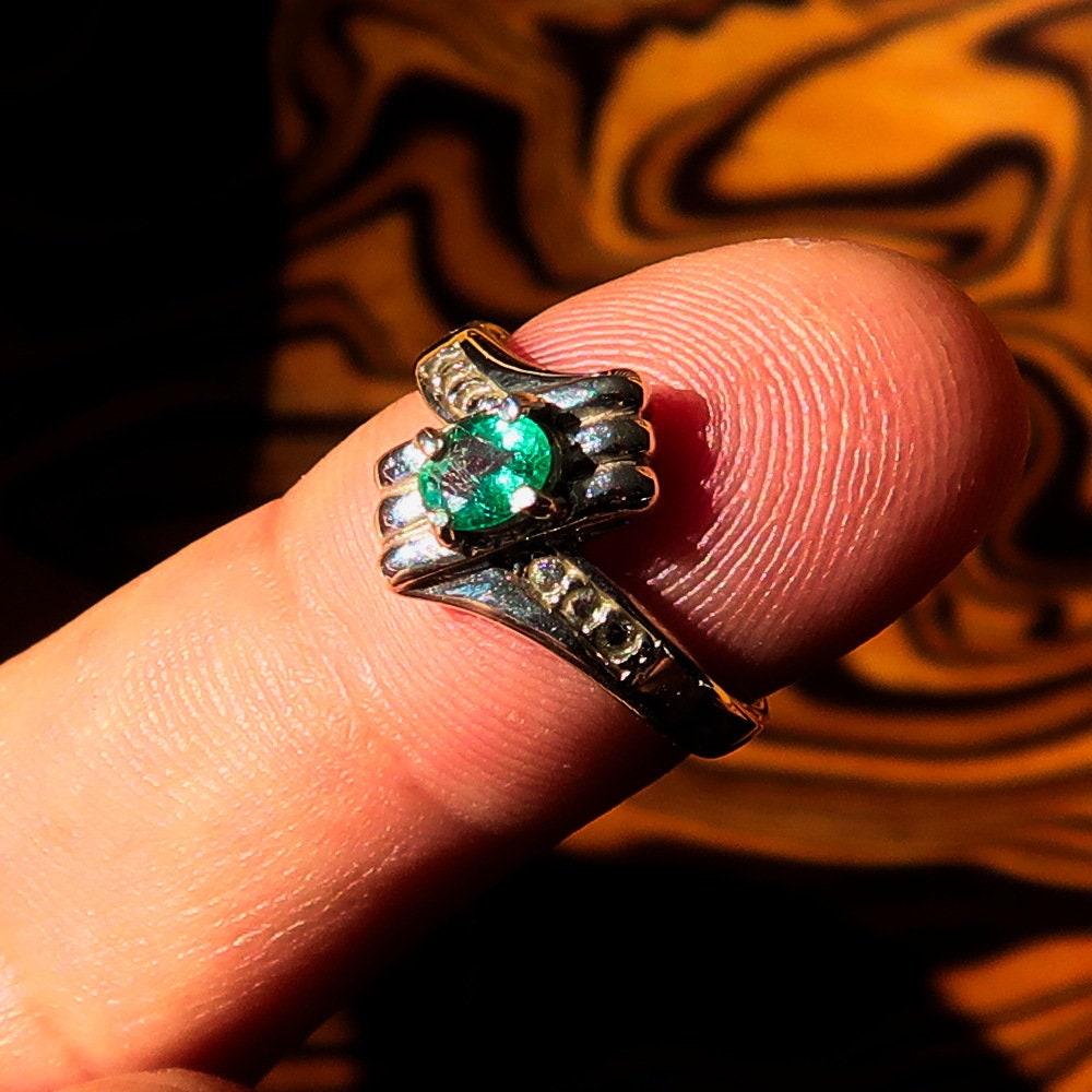 Handmade sterling silver emerald ring featuring an oval cut green emerald and six cubic zirconia stones, hallmarked 925.